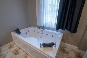 a white bath tub in a bathroom with a window at Demirkapı Otel in Uzungöl +33 photos