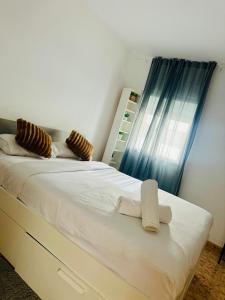 a bedroom with a large white bed with a window at Fórmula 1 aeropuerto in Madrid
