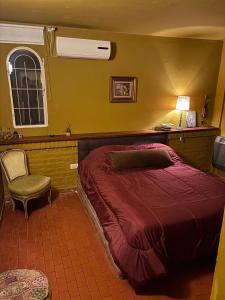 a bedroom with a large bed and a chair at Casa de Barro in Junín