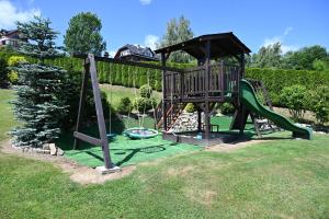 a playground with a slide in a yard at U Mateusza 607-737-859 Widok na Jezioro Solińskie in Polańczyk