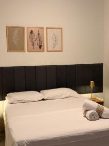 a bedroom with a bed with four pictures on the wall at Studio completo em Diamantina-MG in Diamantina