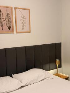 a bedroom with a black headboard and three framed pictures at Studio completo em Diamantina-MG in Diamantina +3 photos