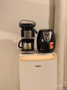 a coffee maker and toaster sitting on top of a refrigerator at Studio completo em Diamantina-MG in Diamantina