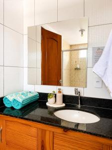 a bathroom with a sink and a mirror at Atins Suites in Atins +25 photos