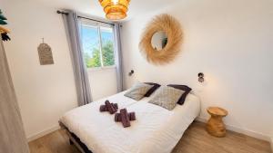 a bedroom with a bed with white sheets and a mirror at Les Baux 1 in Sanary-sur-Mer +3 photos