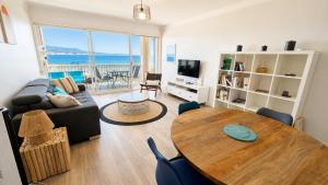 a living room with a table and a couch at Les Baux 1 in Sanary-sur-Mer