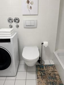 a white bathroom with a toilet and a sink at Gemütliche Wohnung am Bodensee - Self-CheckIn in Markdorf +25 photos