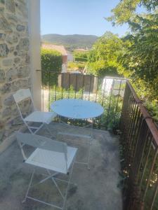 a patio with a table and chairs on a balcony at Theana in Cazilhac