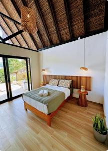 a bedroom with a large bed and a wooden floor at Majaz Cabaña Premium Paucar in Sauce
