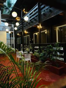 a restaurant with a table and chairs and plants at Hotel Inn morjim in Morjim