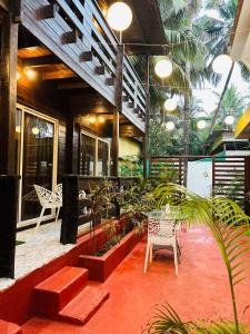 a patio with a table and chairs and plants at Hotel Inn morjim in Morjim +22 photos