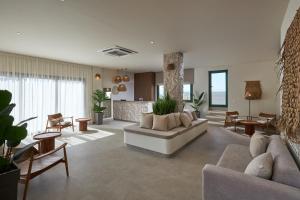 a living room with a couch and tables and chairs at Mila Sissi Bay Hotel in Sisi