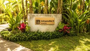 a sign in a garden with flowers and plants at Indraprastha 2 Bungalow in Ubud