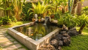 a koi pond with a statue in a yard at Indraprastha 2 Bungalow in Ubud +19 photos