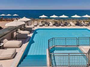 a swimming pool with chairs and umbrellas and the ocean at Mila Sissi Bay Hotel in Sisi +74 photos