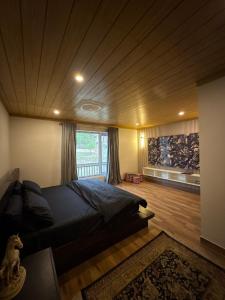 a bedroom with a large bed and a large window at The Elysian Villa in Murree
