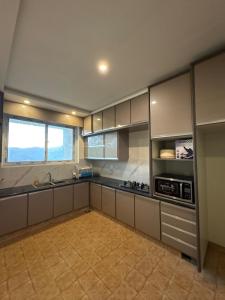 a large kitchen with a sink and a microwave at The Elysian Villa in Murree