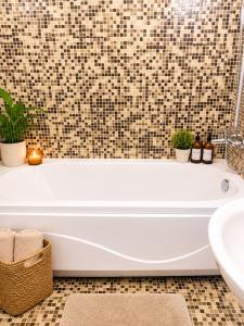 a bathroom with a tub and a sink at Bellissima Studio Sarafovo е вашият уютен дом само на 3 минути от плажа in Burgas