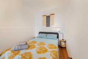 a bedroom with a bed with a yellow and blue blanket at Casa Limão in Charneca