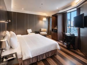 a hotel room with a large bed and a desk at Hotel Relax I in Taipei