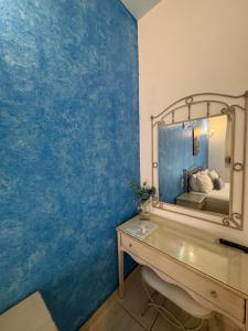 a bathroom with a blue wall with a mirror at Villa Antonis in Parga
