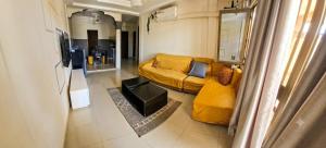 a living room with a yellow couch in a room at BKSF Wemtenga 1 in Ouagadougou