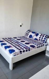 a bed with blue and white sheets and pillows on it at BKSF Wemtenga 1 in Ouagadougou