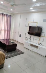 a living room with a flat screen tv on a wall at BKSF Wemtenga 1 in Ouagadougou