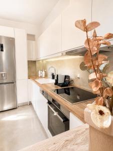 a kitchen with white cabinets and a stainless steel refrigerator at NŌSSA Boutique Apartment in Naousa