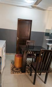 a dining room with a black table and two chairs at BKSF Wemtenga 1 in Ouagadougou +1 photo