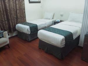 a hotel room with two beds and a chair at أمواج البحر حي البوادي in Jeddah