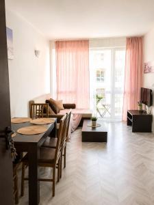 a living room with a table and a couch at Bellissima Studio Sarafovo е вашият уютен дом само на 3 минути от плажа in Burgas