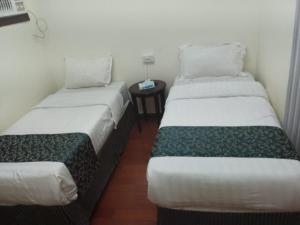 two twin beds in a room with a table at أمواج البحر حي البوادي in Jeddah
