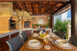 an outdoor dining room with a table and a fireplace at Casa Limão in Charneca