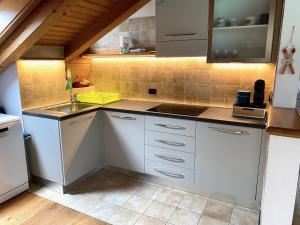a kitchen with white cabinets and a sink at Mansarda vista lago in Auronzo di Cadore
