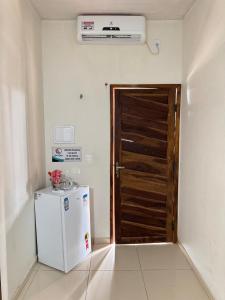 a kitchen with a door and a refrigerator in a room at Solar DorisMar in Luis Correia