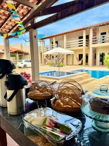 a table with plates of food on a table in front of a pool at Solar DorisMar in Luis Correia