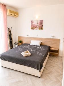a bedroom with a bed with a black comforter at Bellissima Studio Sarafovo е вашият уютен дом само на 3 минути от плажа in Burgas
