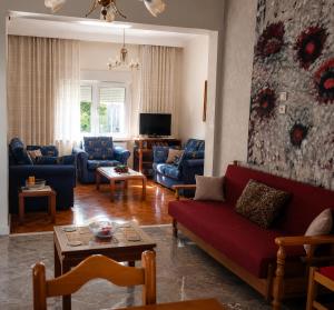 a living room with a red couch and blue chairs at Kolhida home in Kilkis