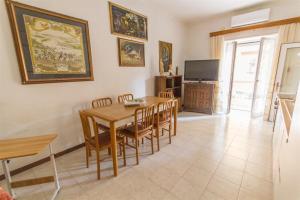 a dining room with a table and chairs and a television at Brezza dell'Argentario in Porto Santo Stefano