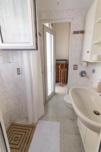 a bathroom with a sink and a toilet and a window at Brezza dell'Argentario in Porto Santo Stefano