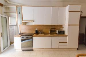 a kitchen with white cabinets and a sink and a stove at Brezza dell'Argentario in Porto Santo Stefano +7 photos