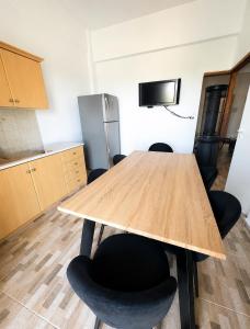 a kitchen with a wooden table and black chairs at Mani Spot Manani in Pyrgos Dirou +10 photos