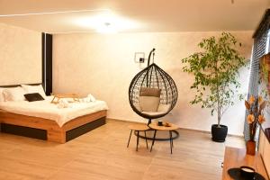 a room with a bed and a swing chair in it at Politon Suites in Zaječar