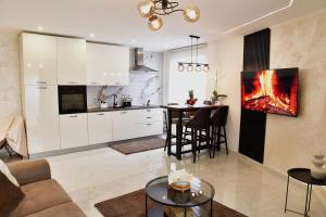 a kitchen and living room with a table and chairs at Politon Suites in Zaječar
