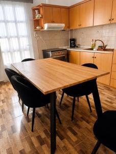 a kitchen with a wooden table and black chairs at Mani Spot Manani in Pyrgos Dirou