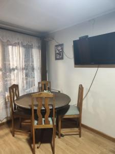 a dining room with a table and chairs and a tv at Cabañas Campestres Las Rosas in Punta Arenas