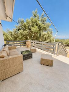 a patio with couches and tables and a fence at Mani Spot Manani in Pyrgos Dirou