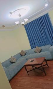 a living room with a blue couch and a table at أمواج البحر حي البوادي in Jeddah +1 photo