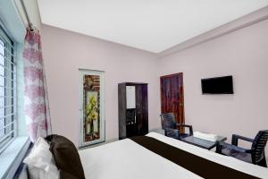 a bedroom with a bed and a tv in it at Hotel O Candel Light Inn in Bhubaneshwar